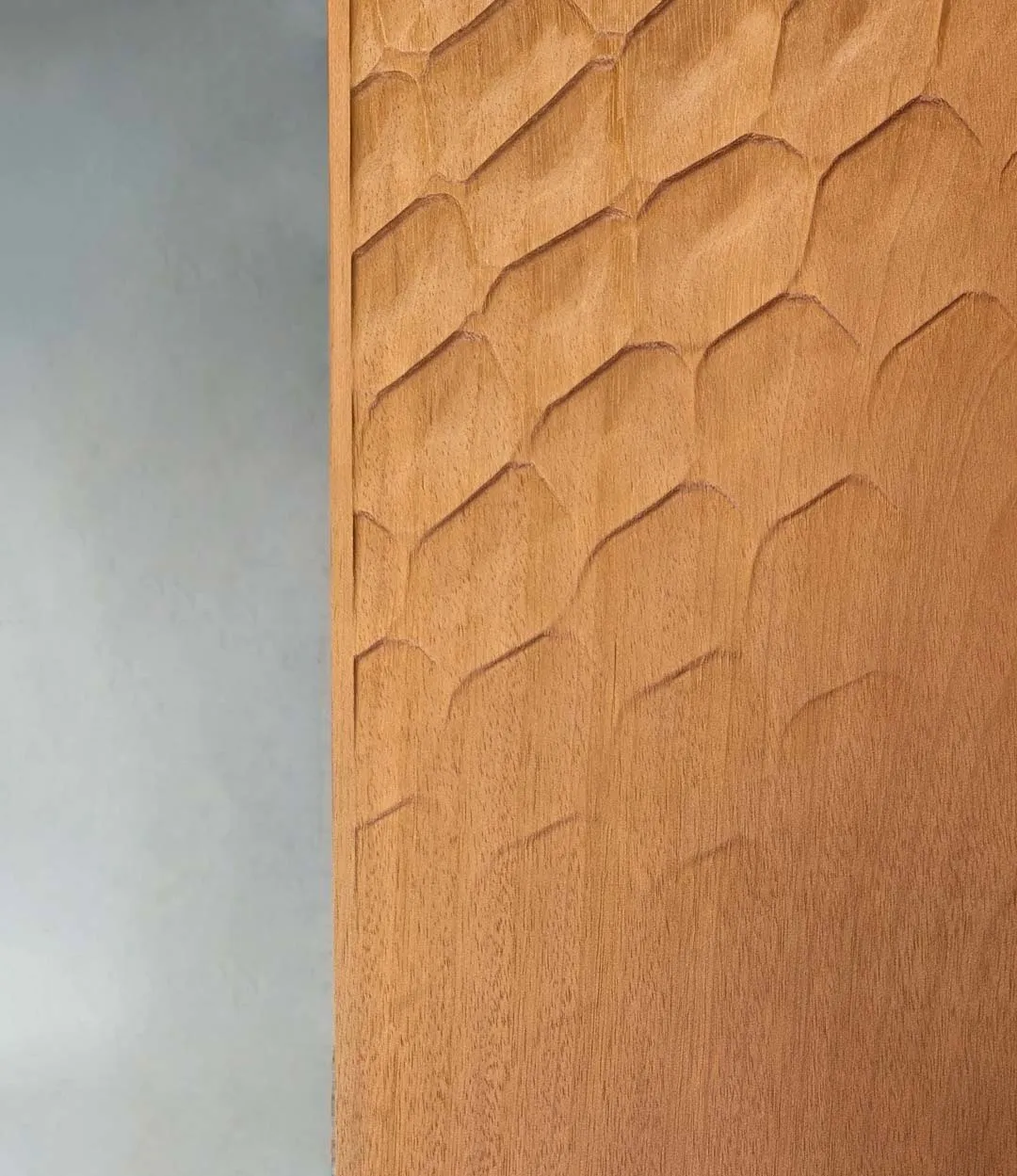 Dettaglio del pannello in legno con fresatura a nido d'ape di una porta d'ingresso su misura, Metalbril