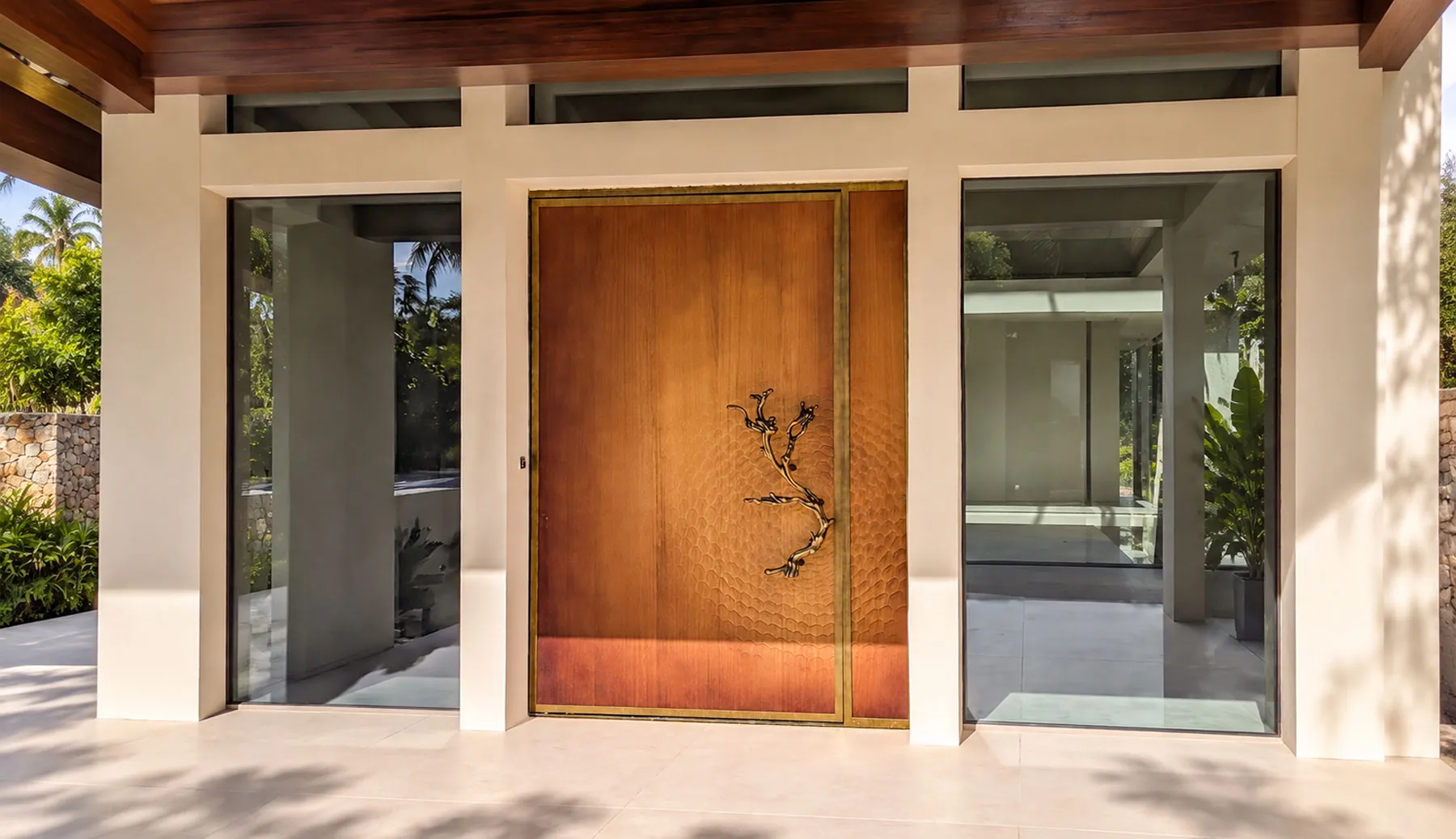 Porta d'ingresso su misura con apertura pivot, pannello fresato a nido d'ape, cornice OxyBrass e maniglia scultorea a ramo, realizzata da Metalbril