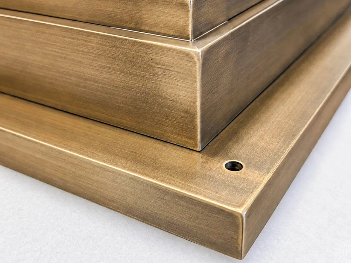 Dettaglio d'angolo del telaio in acciaio inox con finitura OxyBrass effetto ottone ossidato di una porta d'ingresso su misura, Metalbril